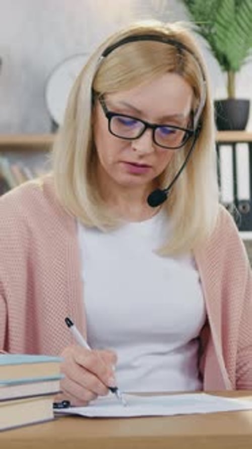Woman Working at Desk Wearing Headset Drinking Coffee
