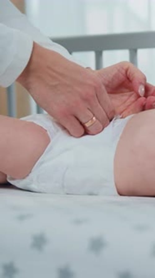 Side View Portrait of Small Baby When His Mother Changing Diaper on the Crib Three Month Old Baby