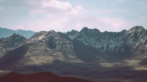Majestic Snow Capped Mountains Under a Clear Sky Near a Serene Valley