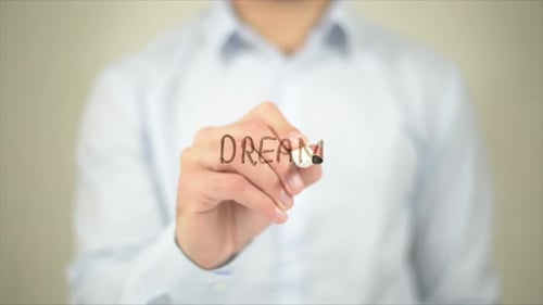 Hand Writing the Word Dream on Clear Surface