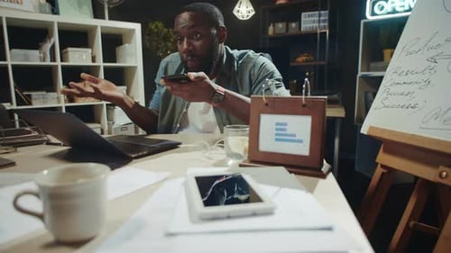 Man Talking on Phone at Desk in Office