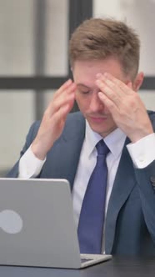 Stressed Businessman Working on Laptop in Office