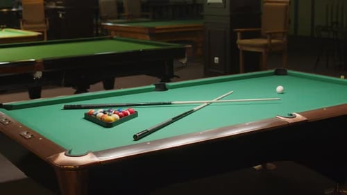 Billiard Table with Balls and Cues in Pub