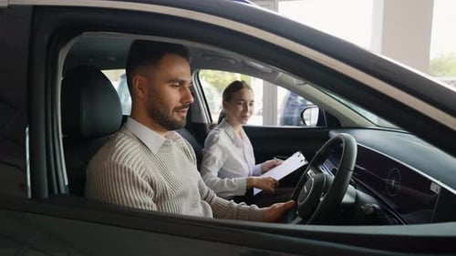 Man and Woman in Car at Dealership