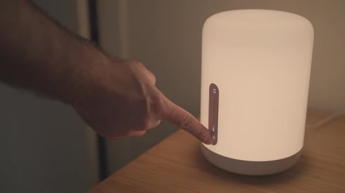 Man Turning Off Smart Lamp