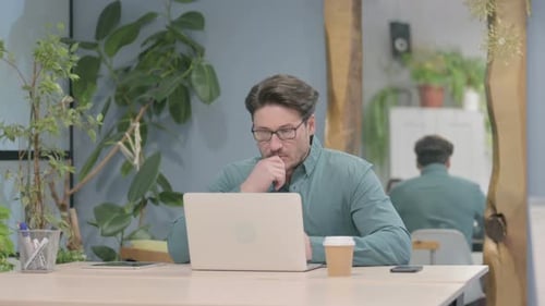 Man Using Laptop in Office Setting