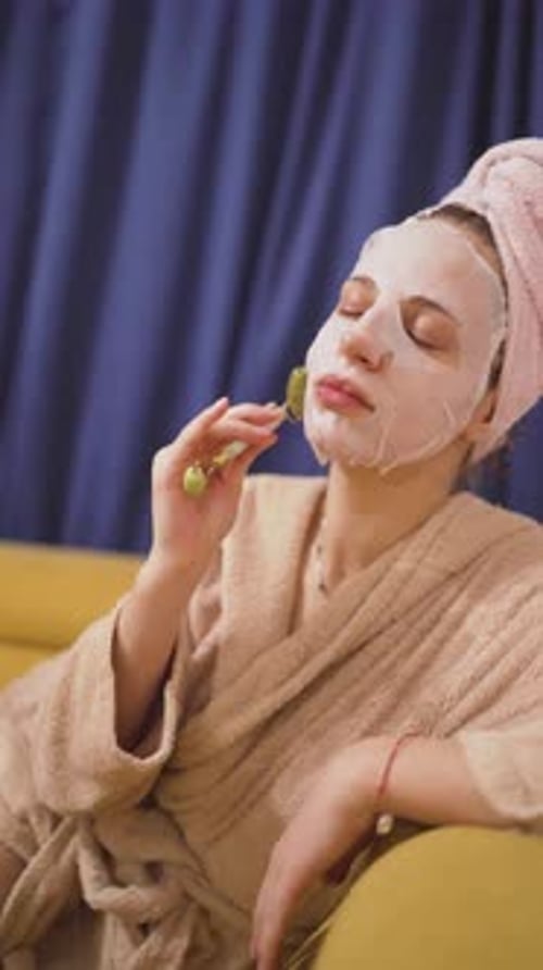 Woman Relaxing with Face Mask and Facial Roller