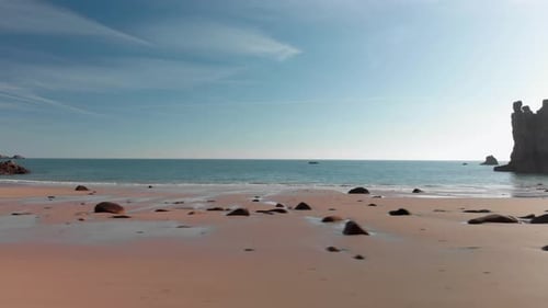 Aerial Shot Above A Sandy Beach With Rocks, Moving From Right To Left