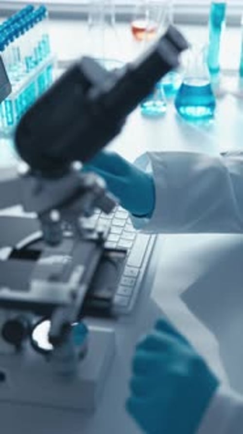 Female Scientist Working with Microscope in Lab