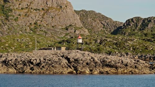 Lighthouse Against The Rugged Mountain Landscape
