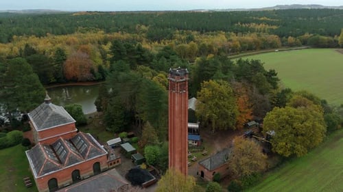 Cinematic Drone Shot of Historic Pumping Station in Autumn Forest Landscape with Fall Colouration