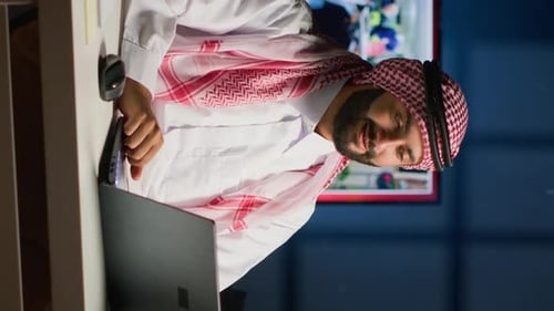 Man Uses Laptop in Office at Night