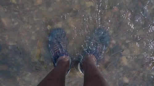 foot in natural clear water river.