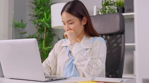 Una joven empresaria frustrada trabaja en exceso hasta tarde en la oficina.