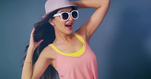 Woman, hat and sunglasses in studio photoshoot, wind and smile for light