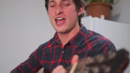Young Adult Man Singing and Playing Guitar