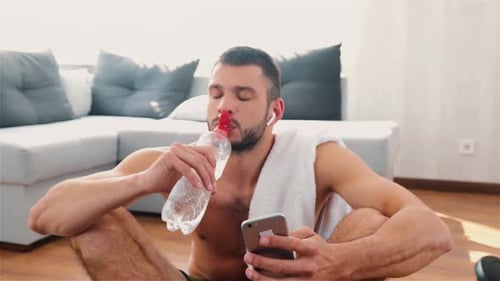 Muscular Man Resting after Workout, Drinking Water