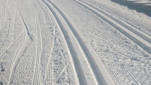 The Camera Moves Along a Perfectly Prepared Ski Slope in a Park on a Ski Track