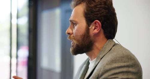 Man Speaking Confidently Wearing a Microphone at Workplace