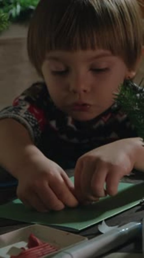 Vertical Video Kid Enjoys Working on Christmas Crafts
