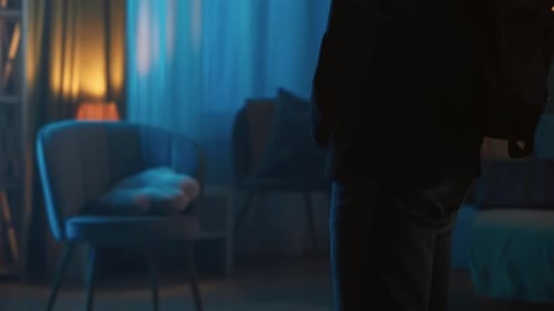 Silhouette Holds Crowbar in Dimly Lit Interior