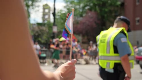 Pride Flag Waving in Crowded Urban Parade