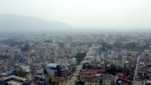 drone aerial view of an urban area with a dense collection of buildings and streets. The background