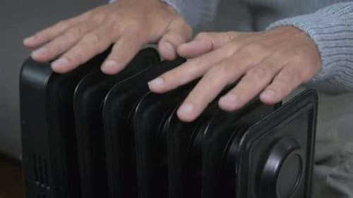 Warming Hands on Radiator Inside on a Cold Day