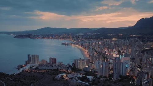 Beautiful modern seafront city with tall buildings at sunset.