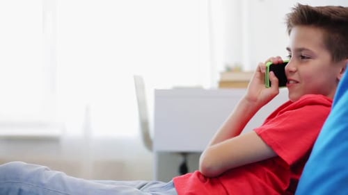 Boy Lying Down Talking on Cellphone in a Room