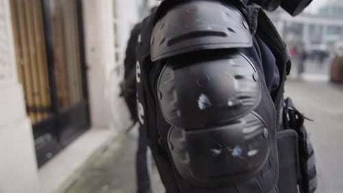 Un policier belge portant un masque à gaz en tenue anti-émeute complète se prépare à des manifestations