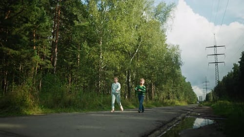 Happy Children Jumping While Walking Through Forest Path