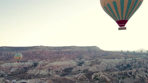 Hot Air Balloons Floating Over Desert Landscape