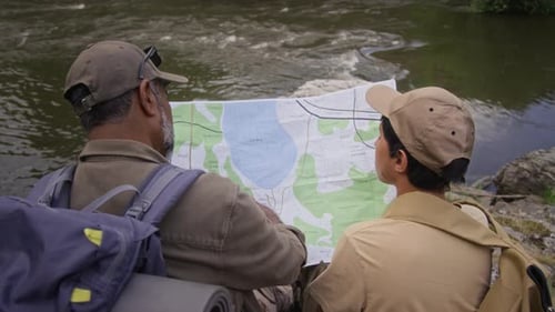 Adult and Teen Exploring Nature with a Map