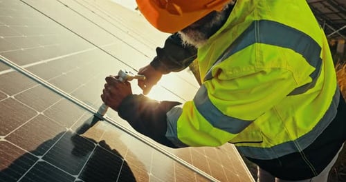 Man Sealing Solar Panels in Rural Environment