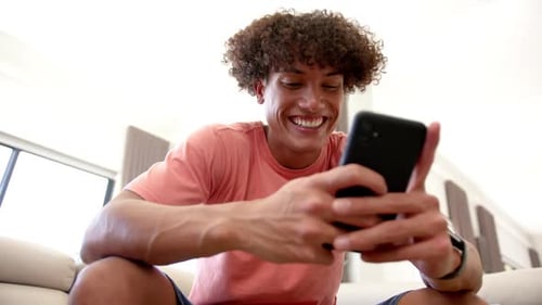 Smiling Man Using Mobile Phone Indoors