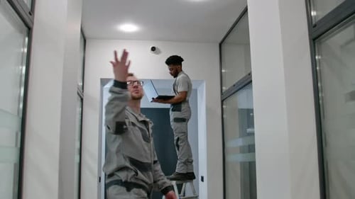 Technicians Configure Security Camera in Office Building