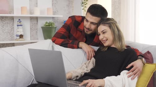 Smiling Couple Using Laptop Together Indoors