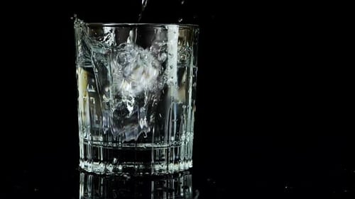 Ice Cubes Falling into Glass of Clear Water