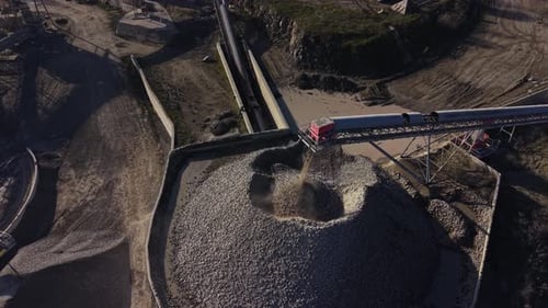 Heavy machinery transports stone material in quarry site near mine