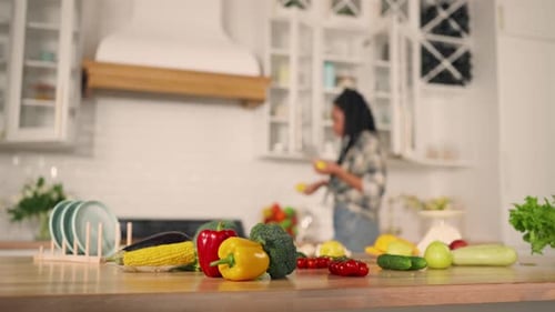 Woman Prepares Vegetables in Bright Kitchen