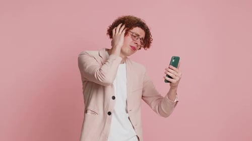 Man Looking at Phone Gets Bad News