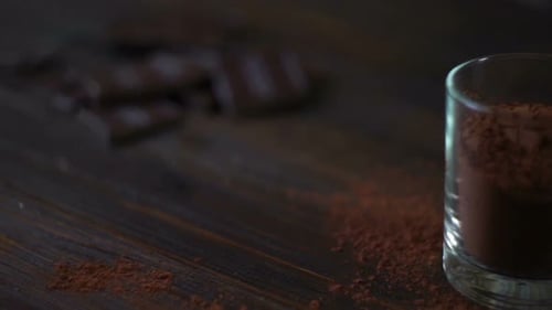 Delicious Chocolate Bars and Cocoa Powder on Wood Table