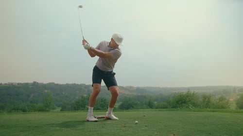 Golfer saca un tiro de hierro desde el tee box con una cálida luz dorada