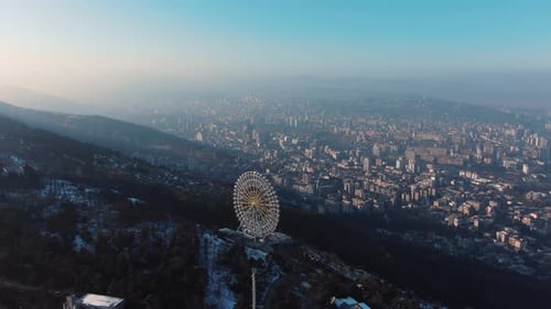 Luftaufnahme des Riesenrads im Mtatsminda-Park mit Blick auf das Stadtbild von Tiflis, Georgia
