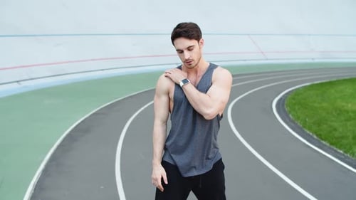 Man Runner Stretching For Workout On Racetrack. Sport Man Stretching On Athletics Stadium. Fitnes...