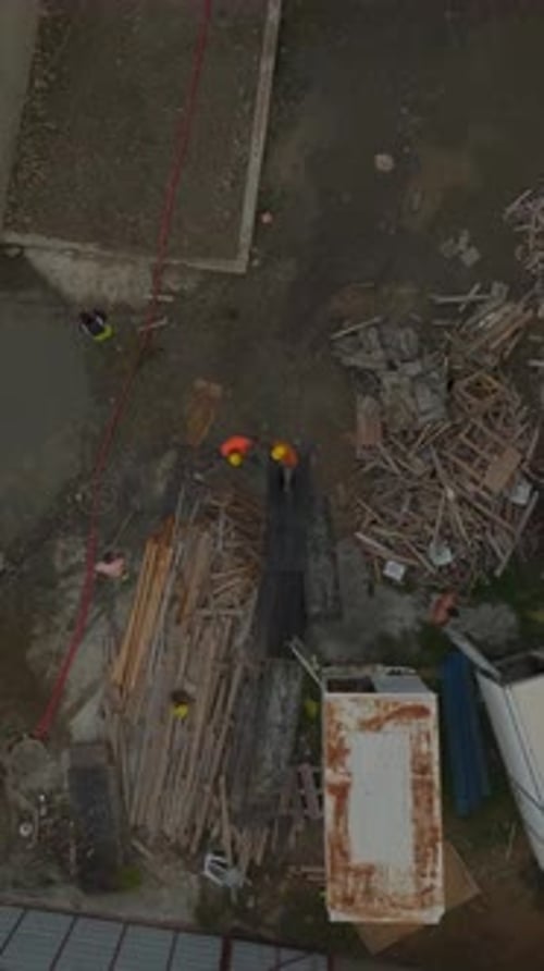 Vídeo vertical: trabajadores de la construcción vierten hormigón para construir los cimientos de un edificio de varios pisos