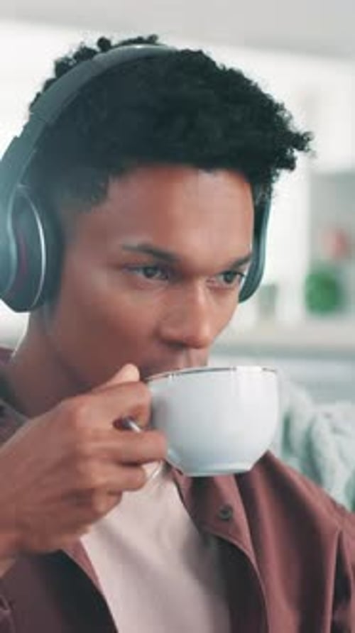 Man Drinking Coffee Wearing Headphones Relaxing Indoors