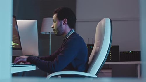 Middle Eastern IT Specialist Program Coding in Dark Office