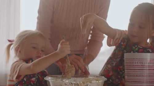 Children and Adult Mixing Batter in Kitchen